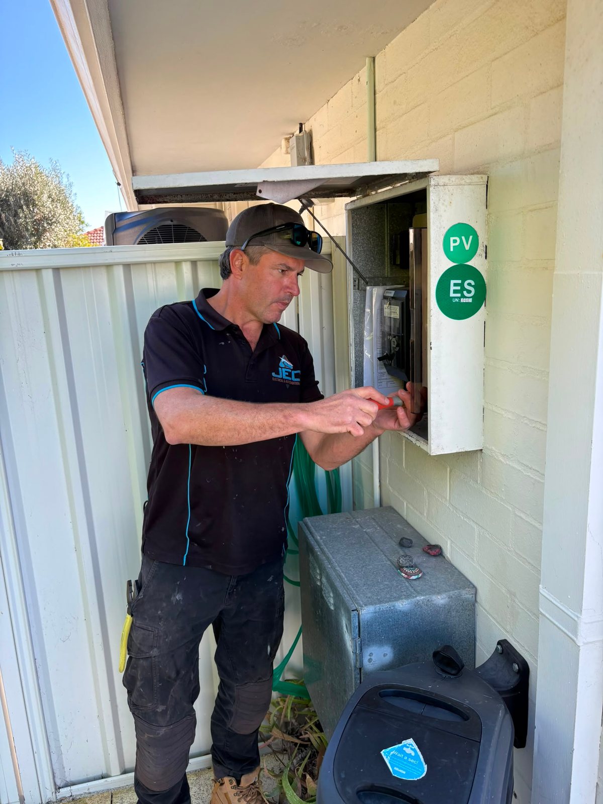 Glen from Joondalup Electrical working at an open residential switchboard.